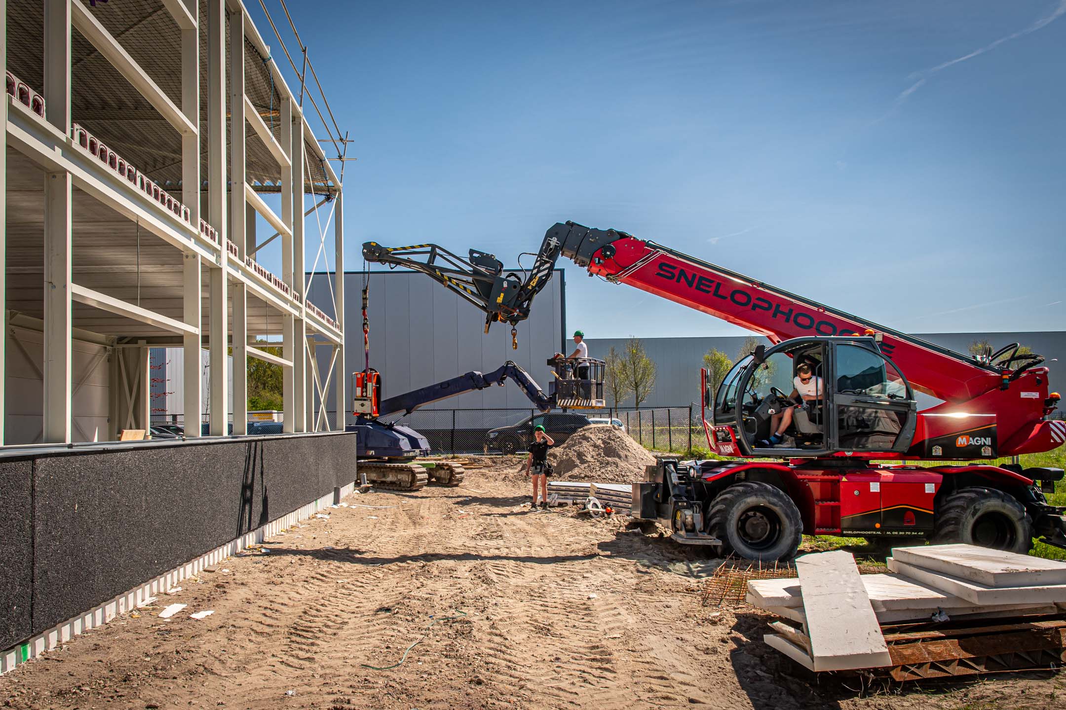Bouwplaats met verreiker bij een nieuwbouwpand