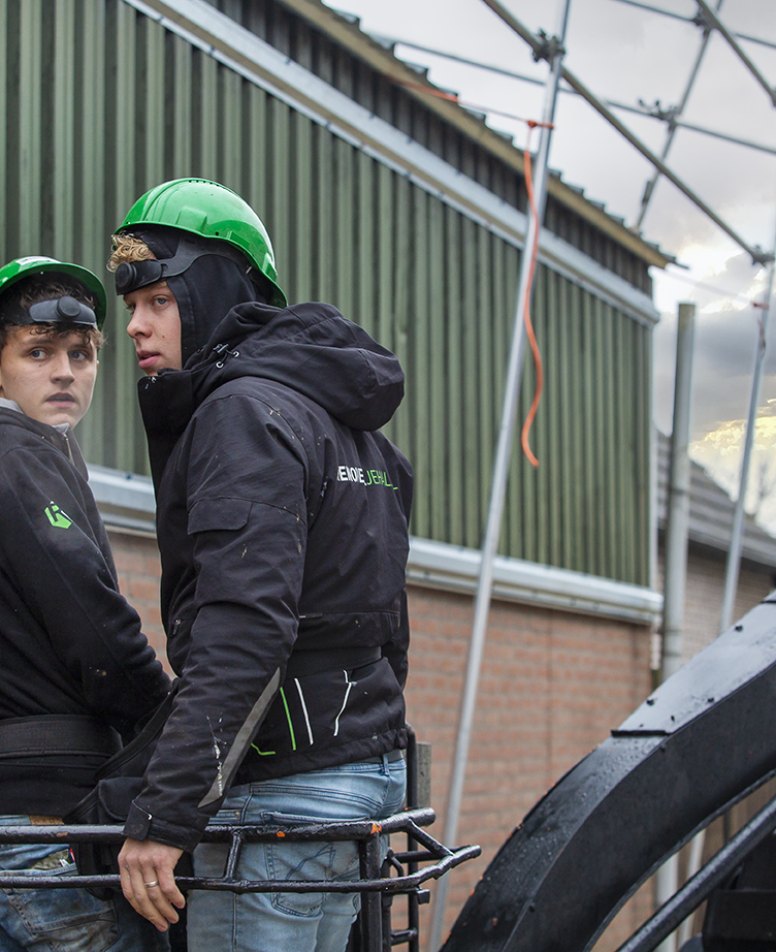 Werkzaamheden aan een gevel bij zonsondergang