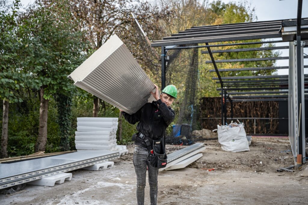 Monteur tilt materiaal op de bouwplaats