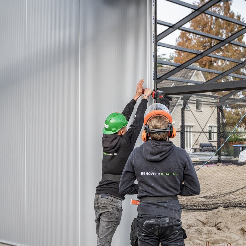 Monteurs plaatsen gevelbeplating bij nieuwbouw